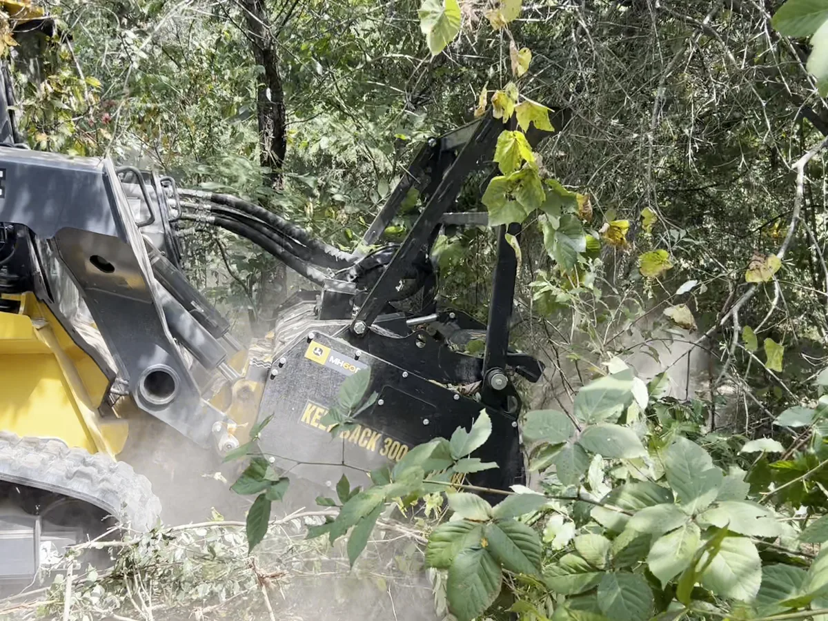 Deere 333P mulching head working under overhanging brush