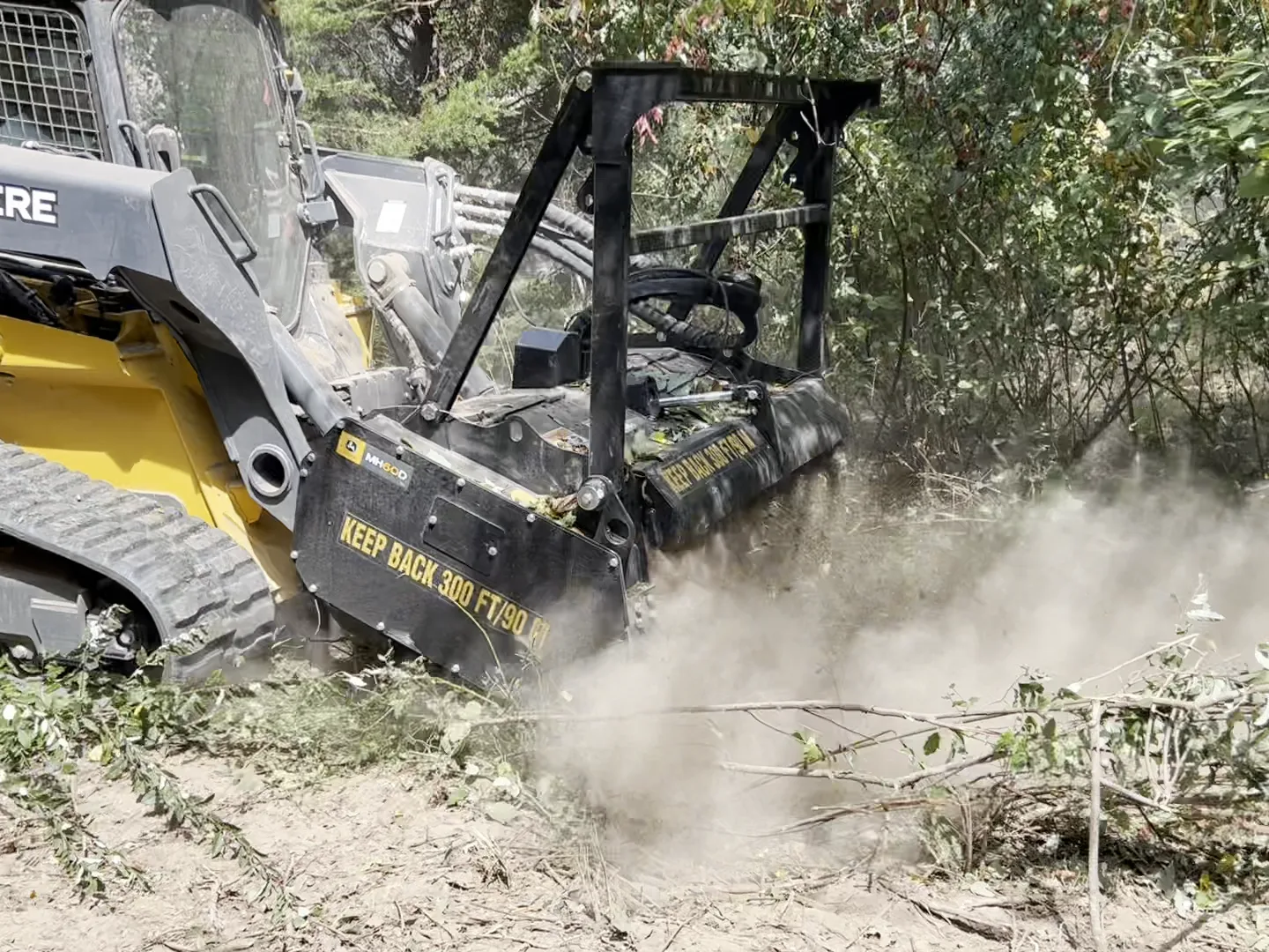 Deere 333P mulcher with the head down grinding brush and saplings